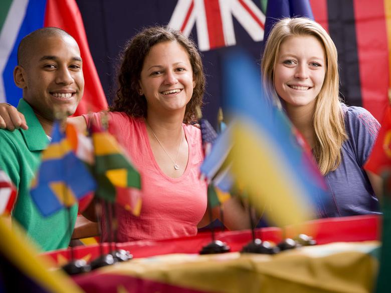 Three students sitting at table smiling